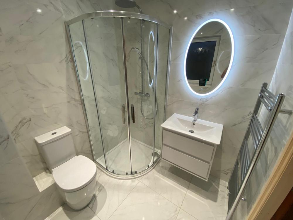Glasgow shower room with white marble-effect tiles and a circular illuminated mirror
