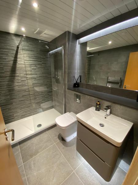 A finished shower room with basin unit, toilet and horizontal feature tiles