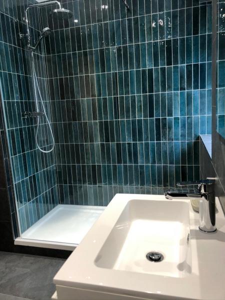 Walk-in shower and basin with blue-green gloss feature tiles